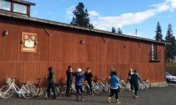 Cyclists get ready for wine-bike tour in front of red barn.