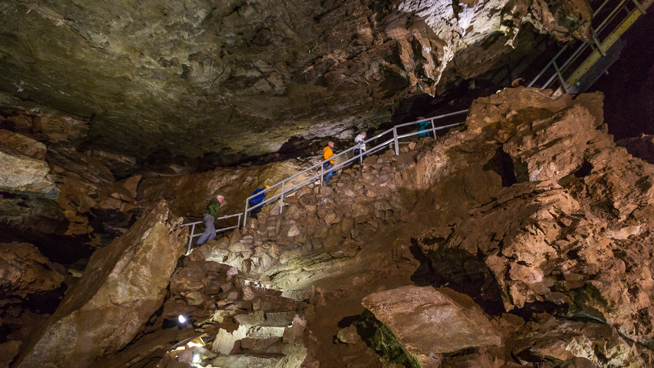 People walking up a staircase in a cave