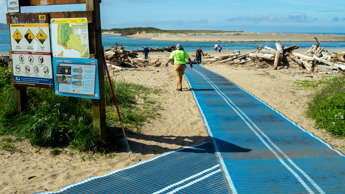 long blue mats lay across sandy beach