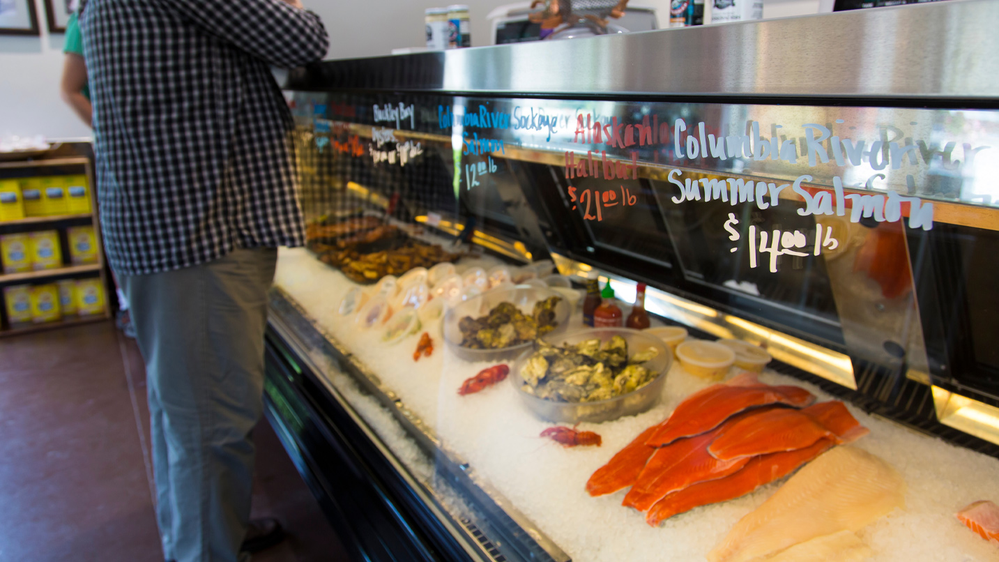 A glass display case shows fresh fish for sale