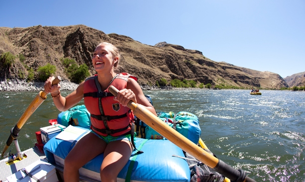 A woman rows a raft on the Snake River through Hells Canyon