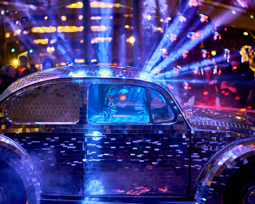Purple and blue lights surround a small car