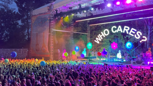 crowd of people under colorful lights in front of stage