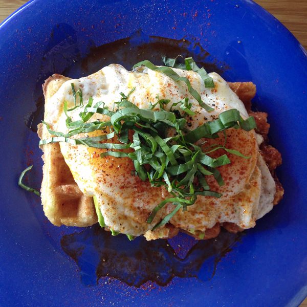 Waffle covered in lots of toppings on a blue plate