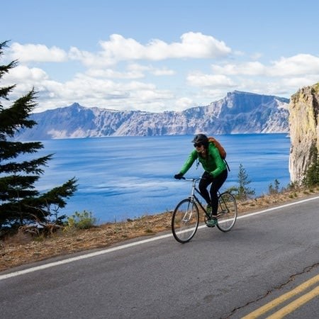 A cyclist riding on the road next to Crater Lake