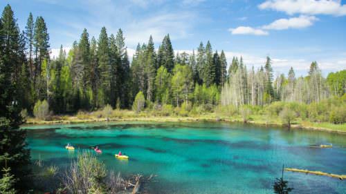 Three kayaks on a crystal clear blue river