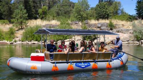 Guests motion cheers aboard a 20-foot inflatable raft
