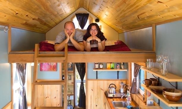 Caravan owners Deb DElman and Kol Peterson pose in loft of trailer
