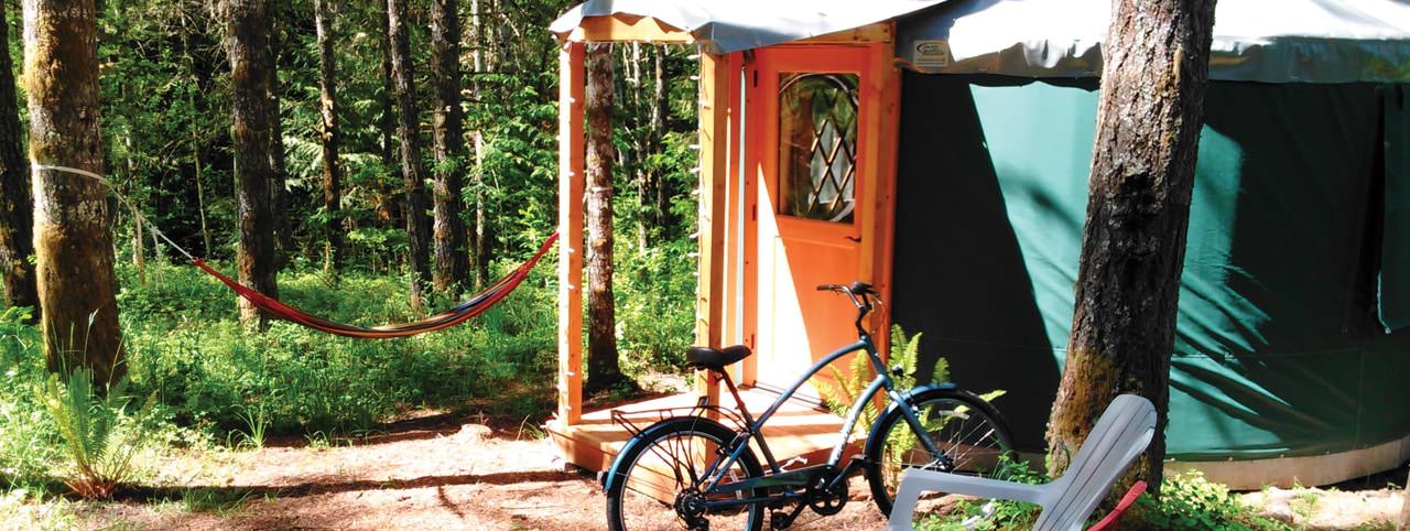 A hammock hangs outside a yurt.