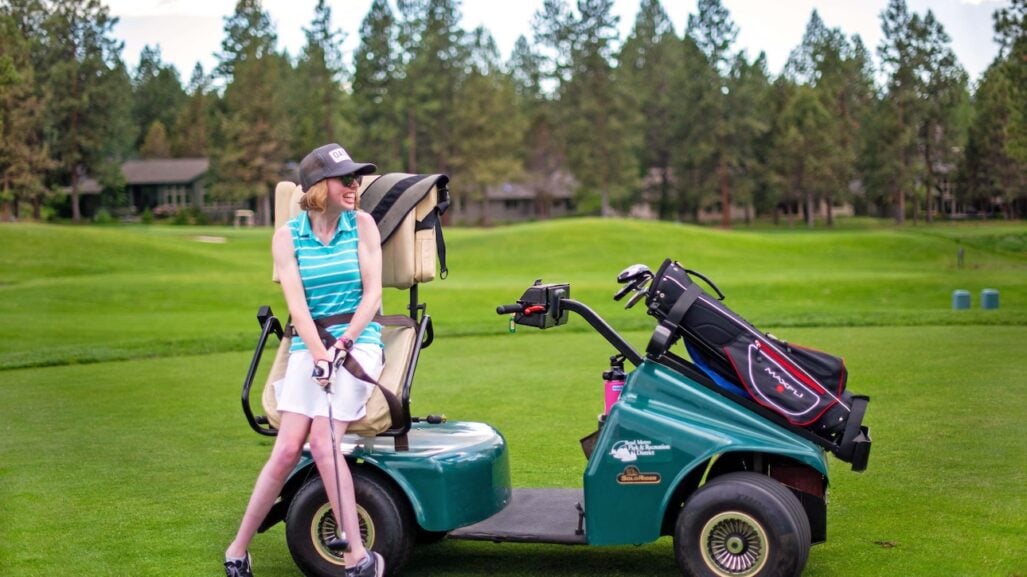 An adaptive golfer sets up for a swing.