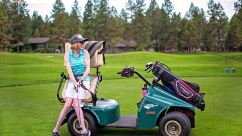 An adaptive golfer sets up for a swing.