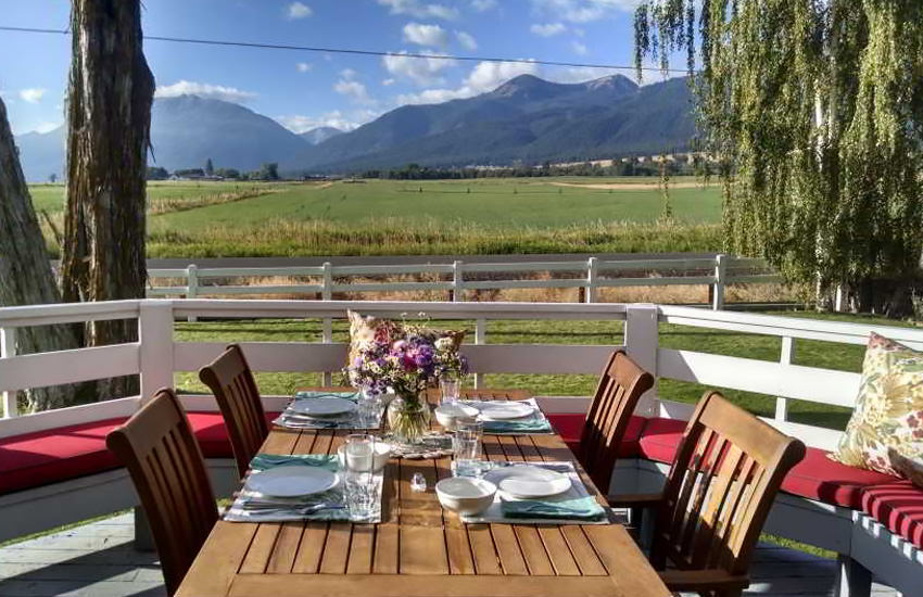 An outdoor table set for four people with a view of mountains