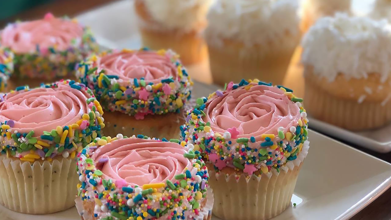 Pink cupcakes with rainbow sprinkles and coconut-cream cupcakes beckon at Sweetheart Bake Shop.