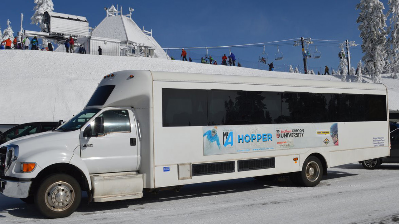 A shuttle bus sits outside a ski lodge