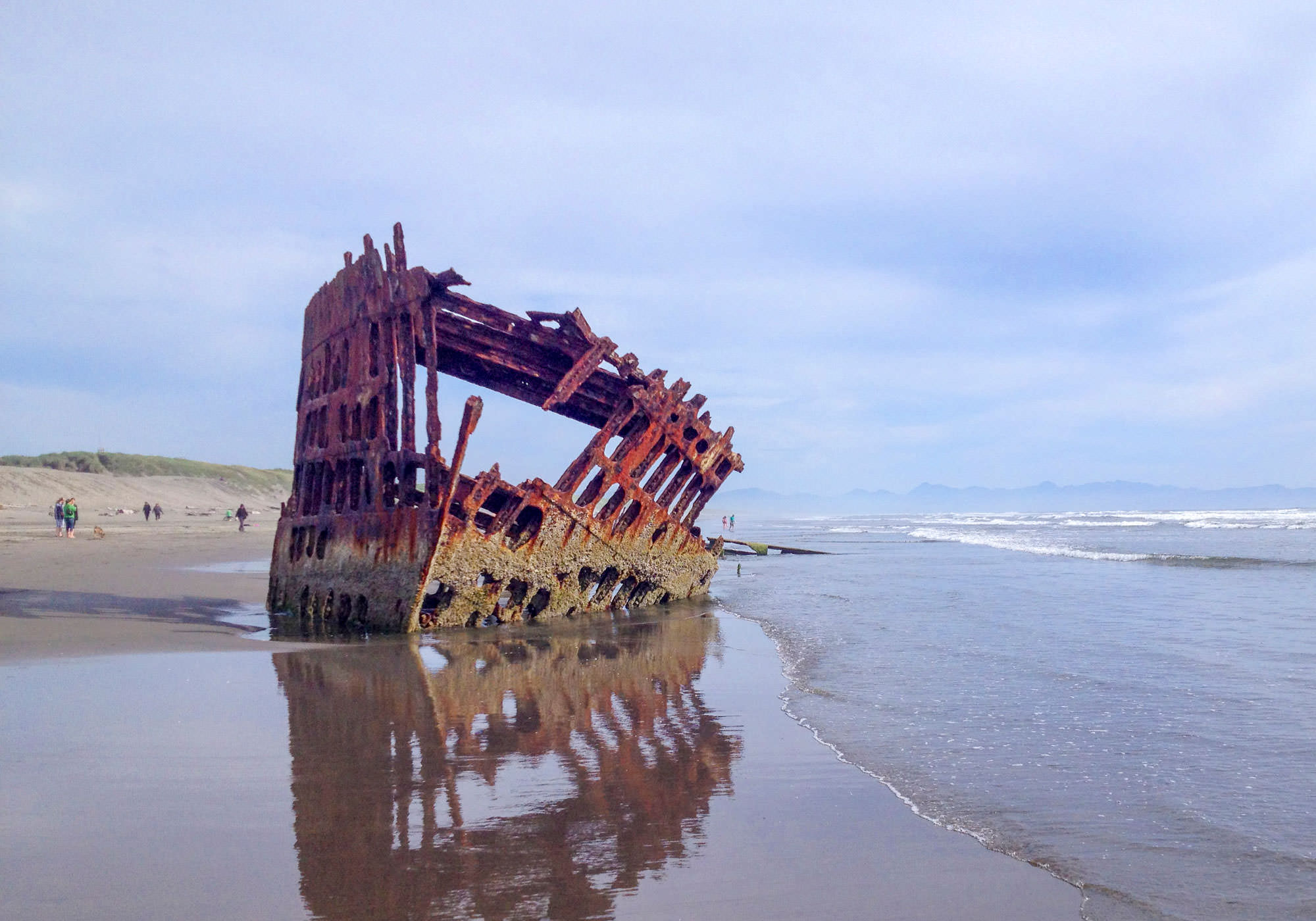 Visitors can walk up to a steel shipwreck weathered by a century at the shoreline.