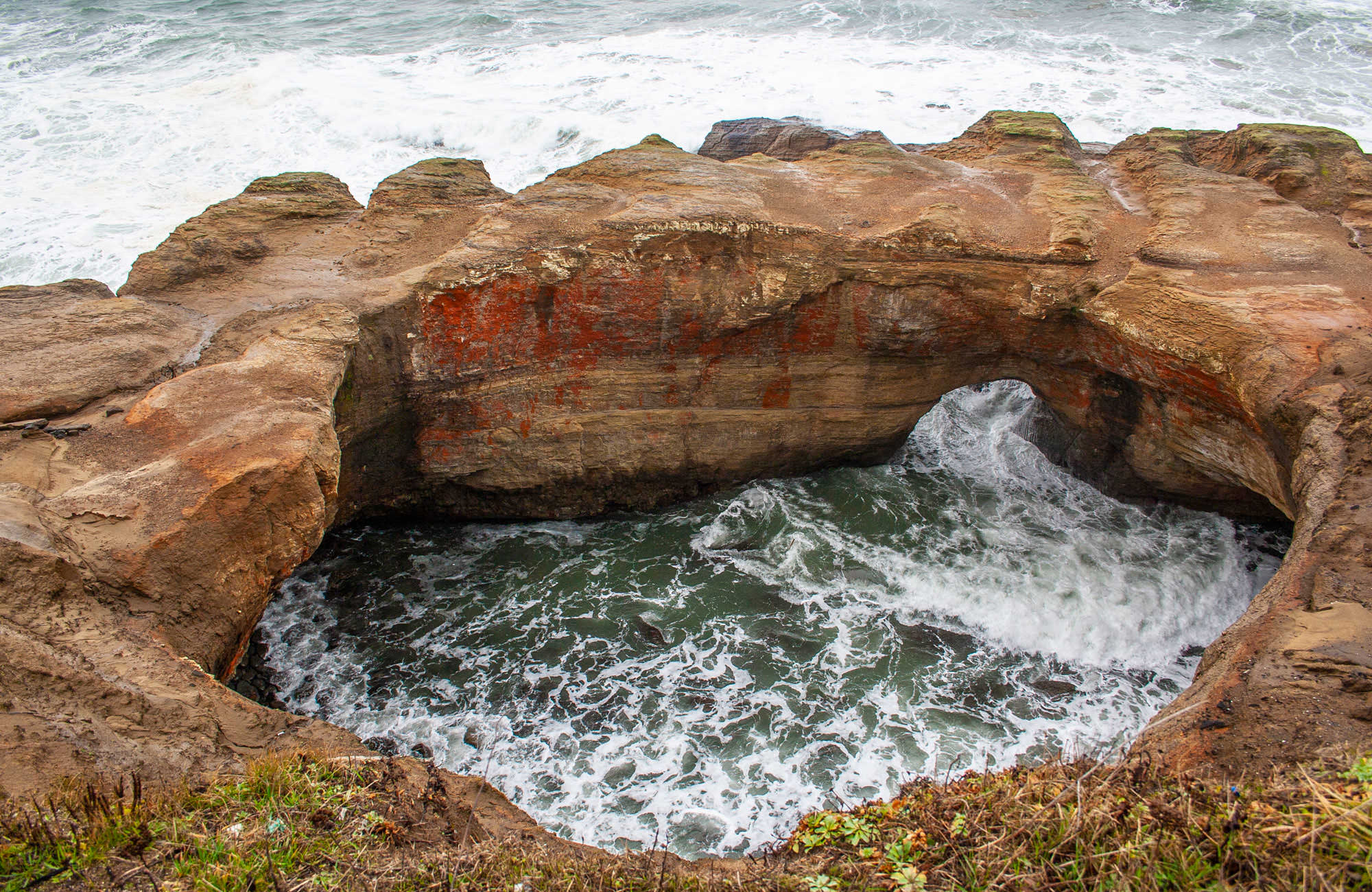 The unique geology of Devils Punchbowl encases roaring ocean water.