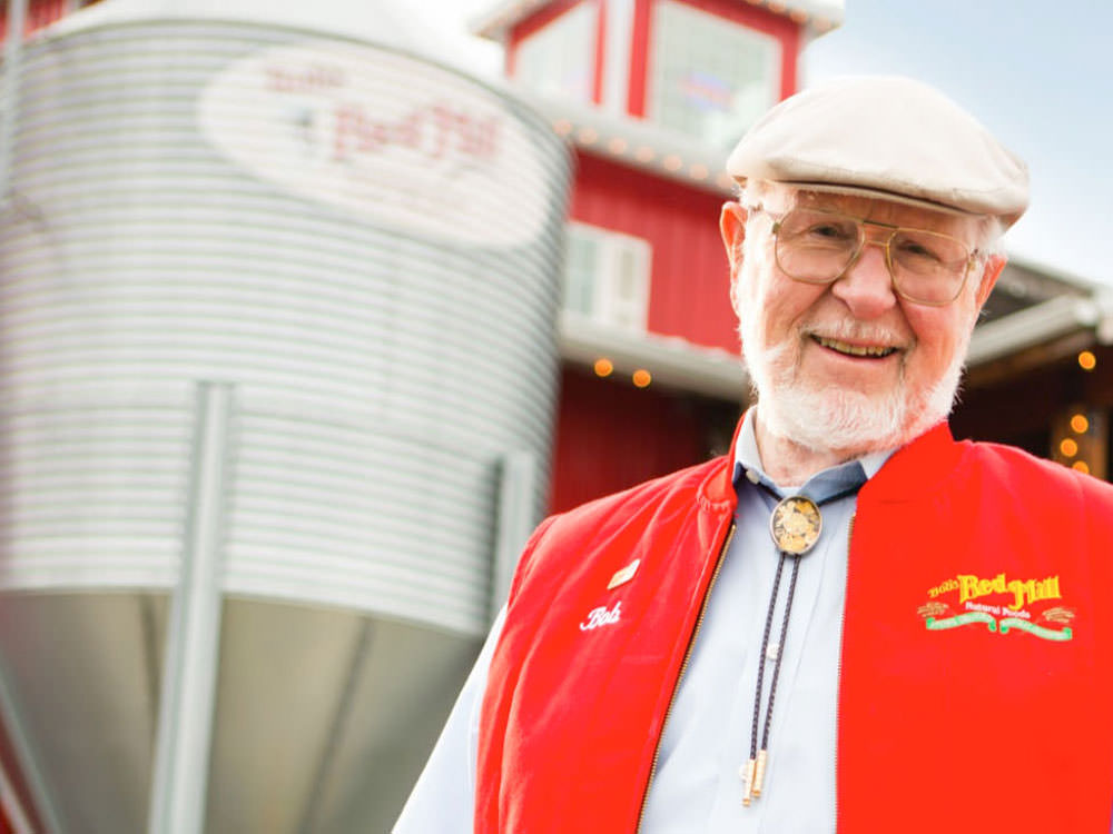 Bob Moore smiles for the camera in front of a silo.