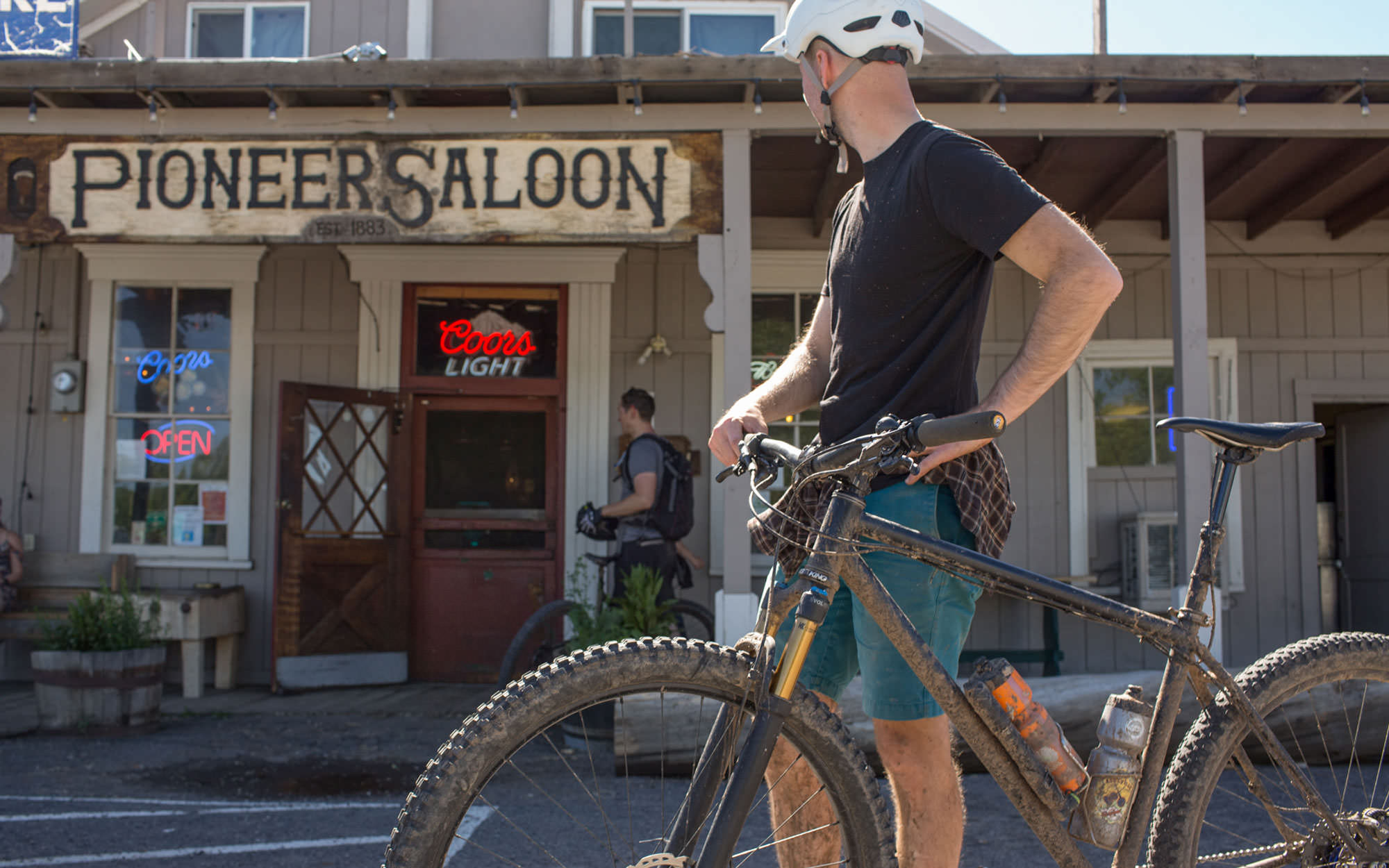 A mountain biker stands outside the Pioneer Saloon in Paisley.
