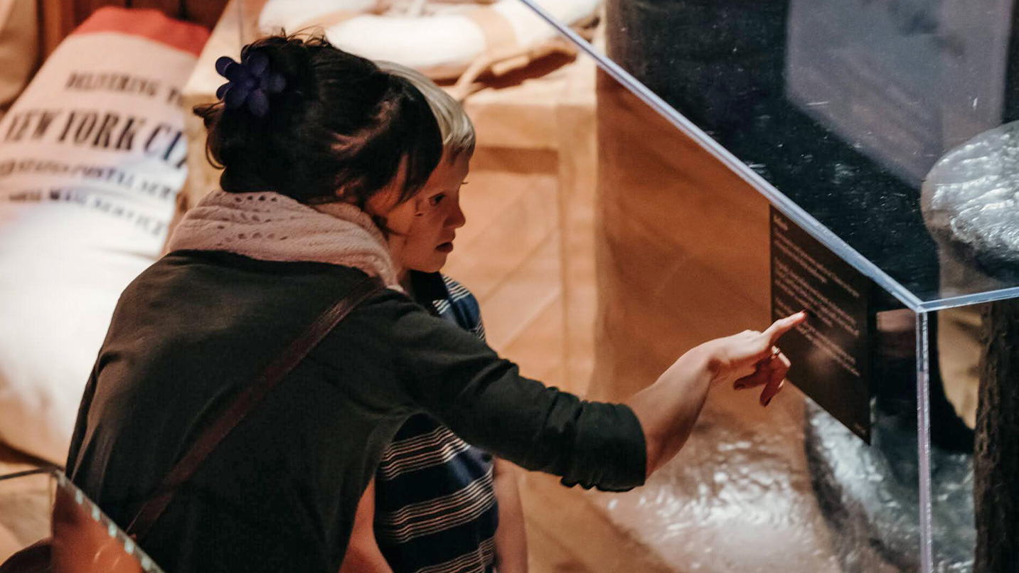 A woman and child looking at a display case.