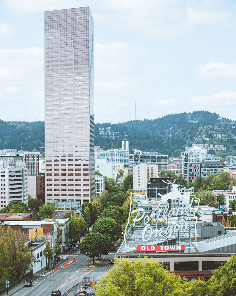 From the sky one can see Portland's iconic Old Town sign, Big Pink building and forested hillsides.