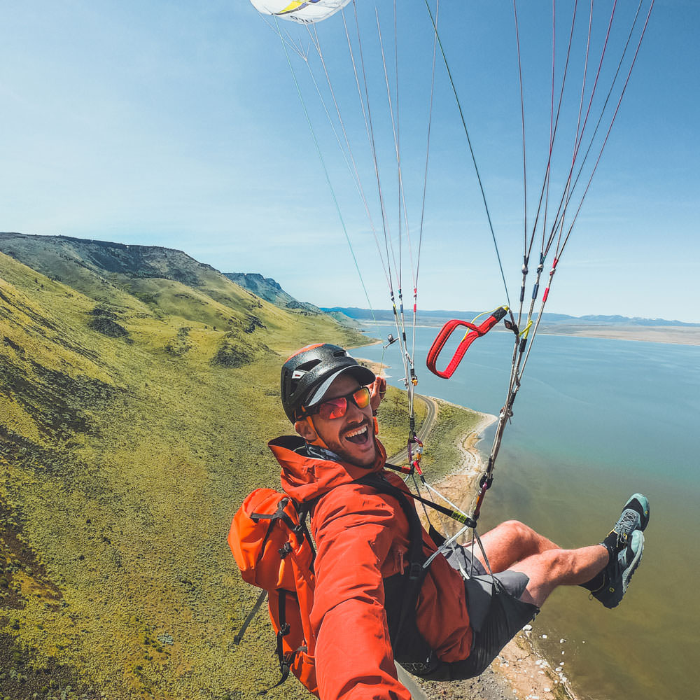 A man takes a selfie while paragliding over the Abert Rim.