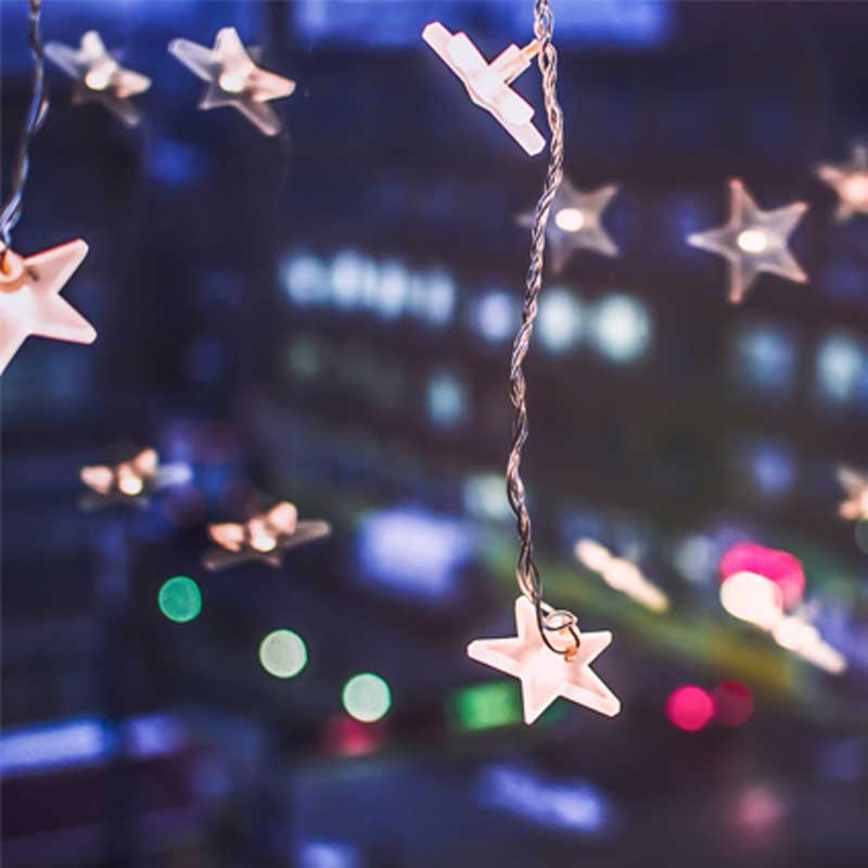 Christmas lights in the shape of stars illuminate the darkness.