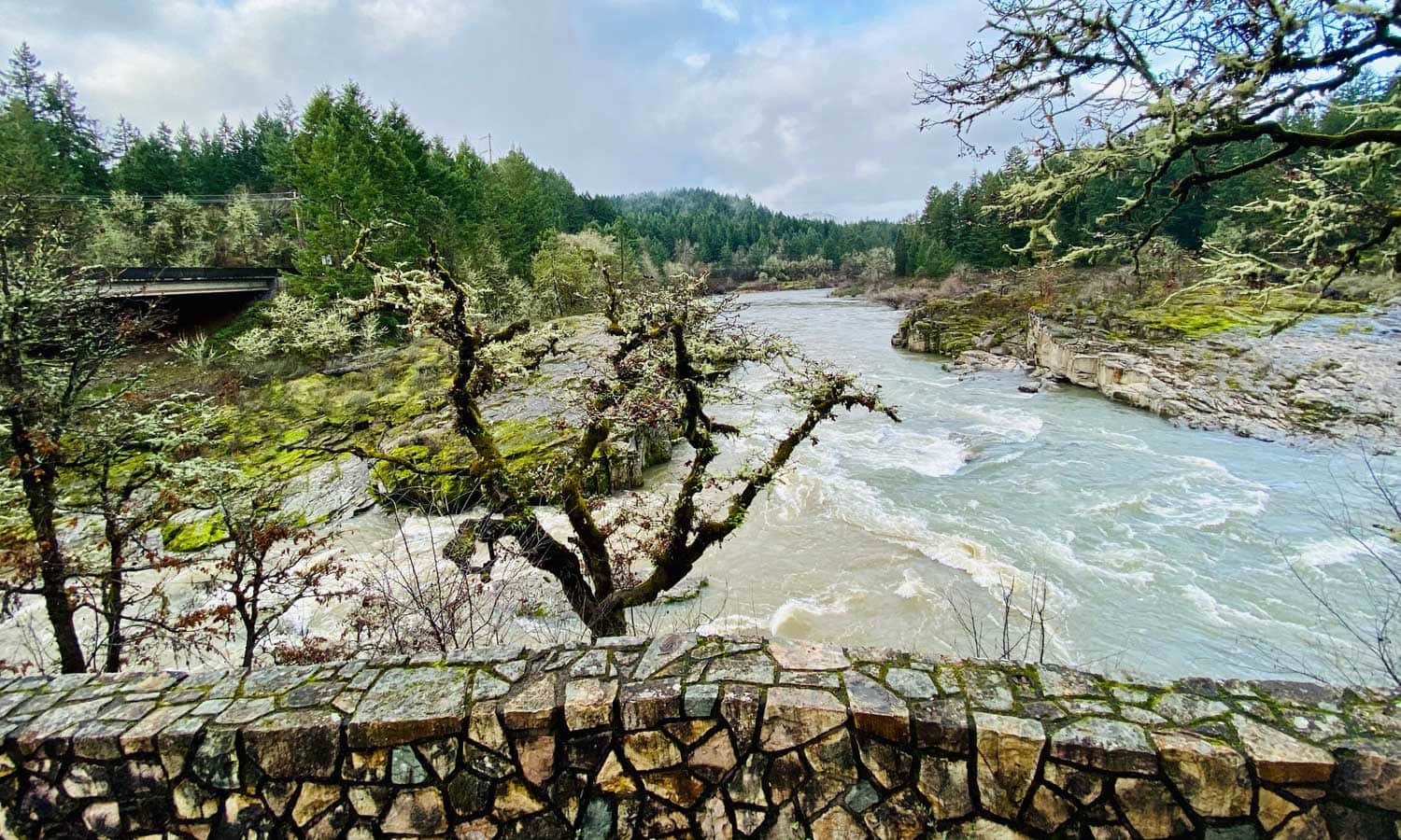A rock barrier separates the viewpoint to the colliding rivers below.