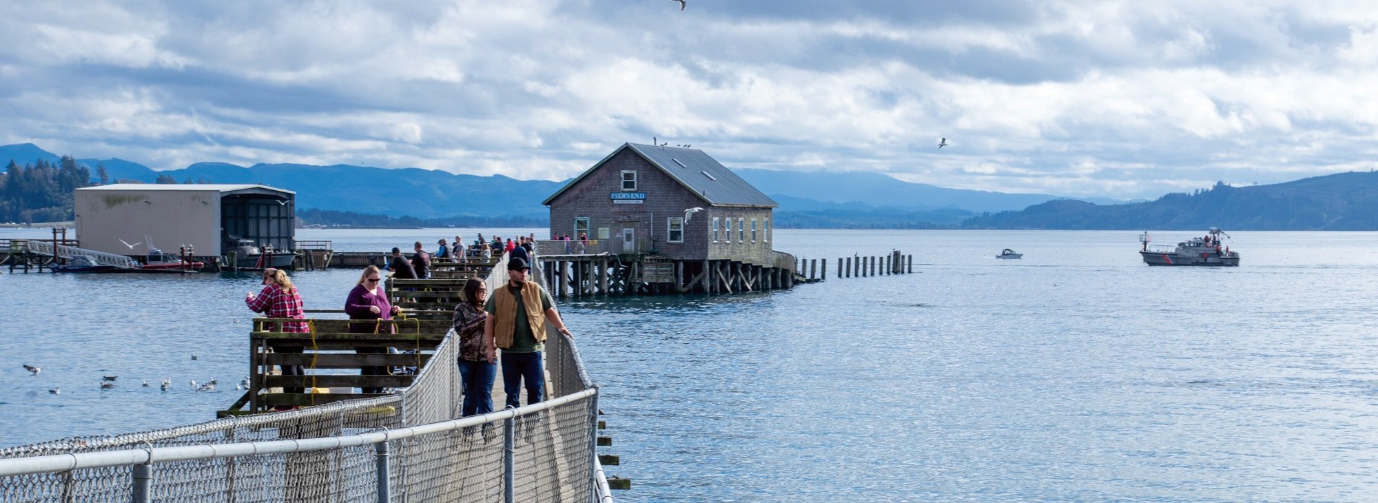 People walking on walkway to building on the water
