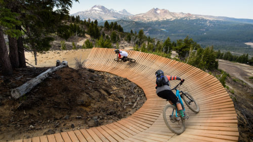 Mountain bikers pedal on the curved boardwalk trail at Mt. Bachelor.