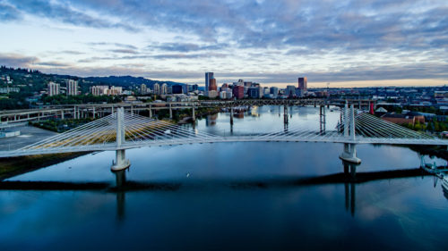 The car-free Tilikum Bridge spans over the blue waters of the Willamette River in Portland.