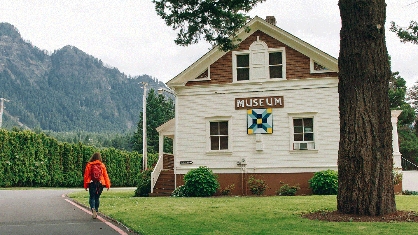 A person walks in front a quaint museum.