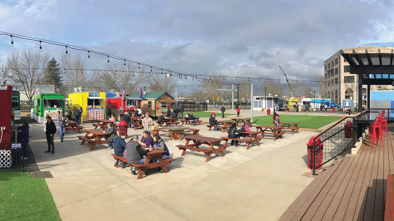 An outdoor patio surrounded by food carts