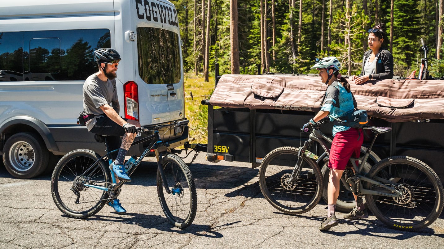 Cyclists load their bikes onto a trailer