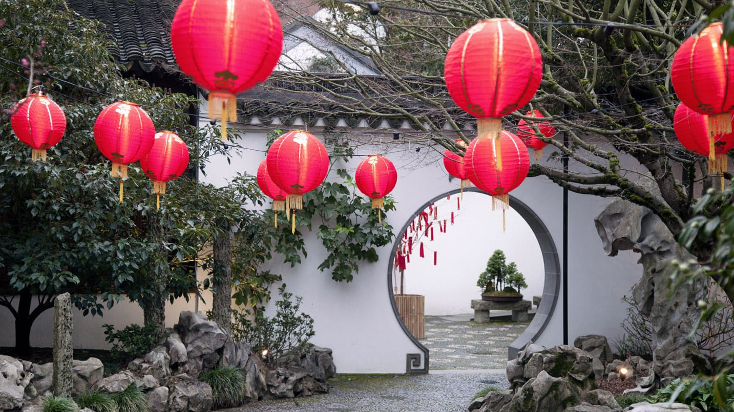 Red lanterns hang from the entrance of Lan Su Chinese Garden.