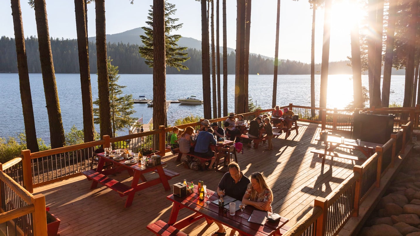 Scenic view of people on a restaurant deck overlooking a lake
