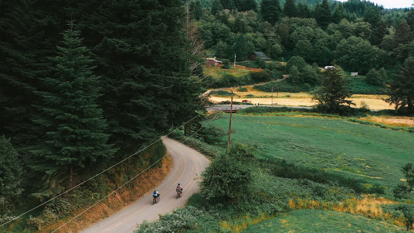 Arial view of two cyclists on a windy country road