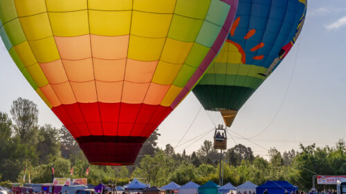 two hot air balloons in the air above festival