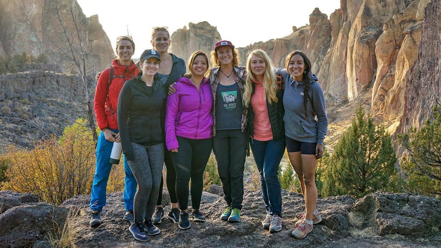 A group of women pose in front of towering rocks