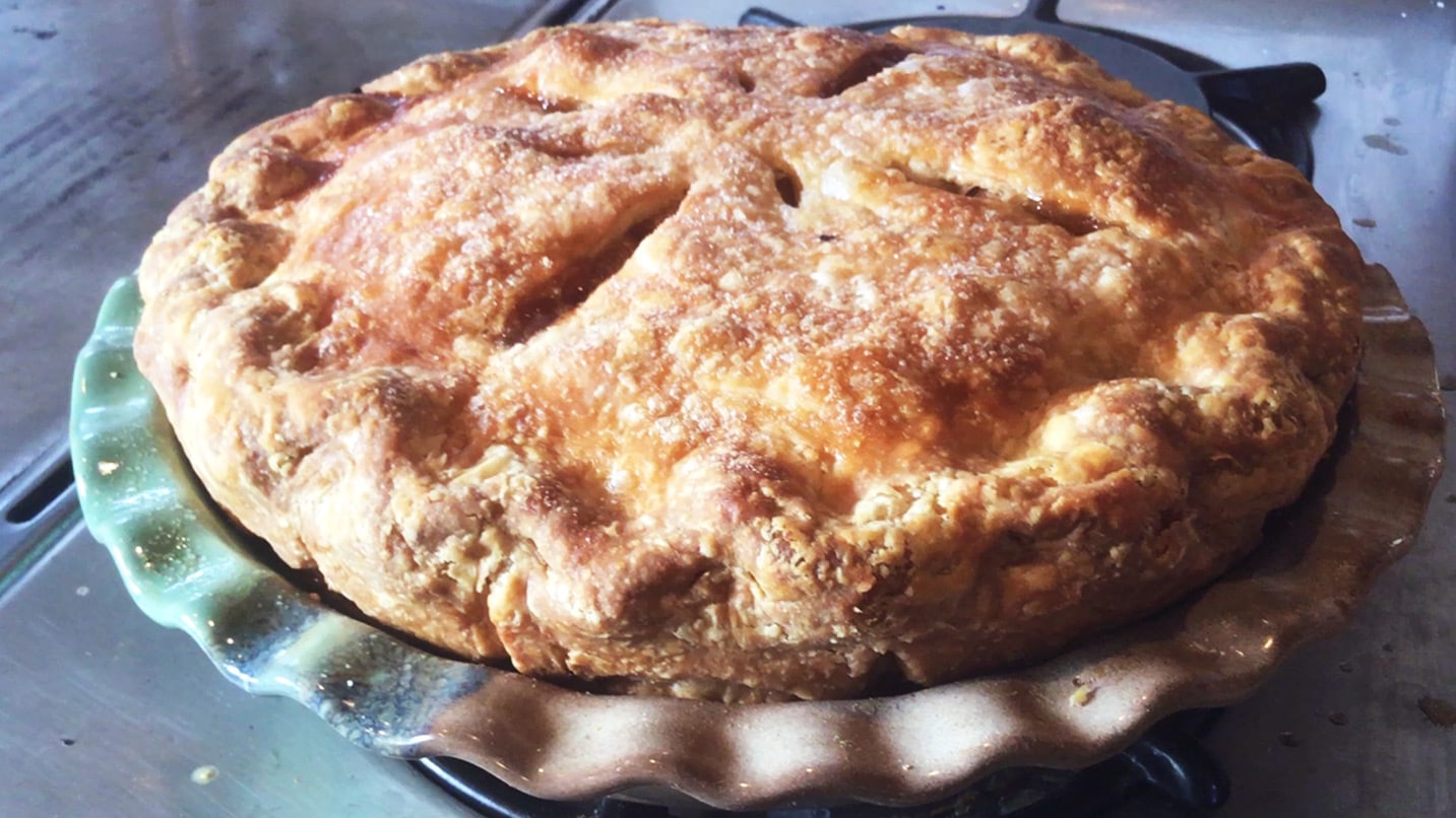 An apple pie sits on a pie dish
