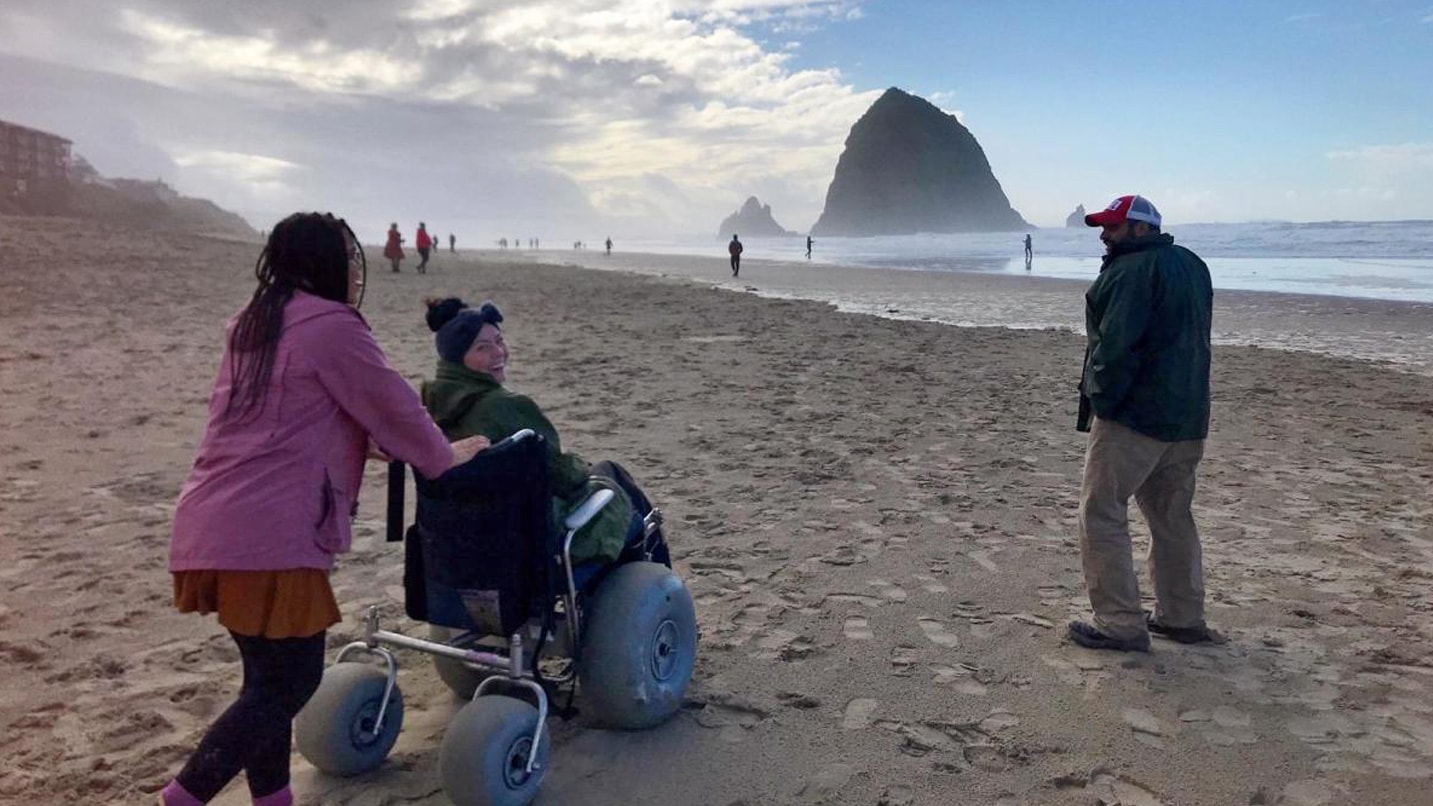 A woman explores the beach in a wheelchair