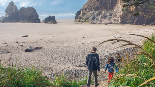 A family walk down a path to a beach
