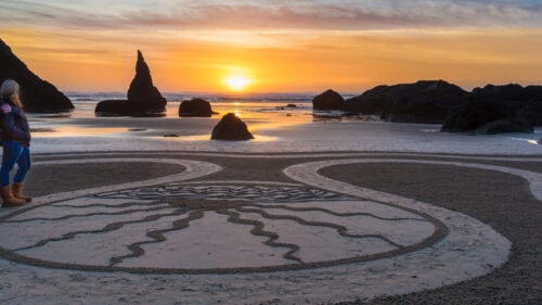 Art is drawn into the sand on a beach