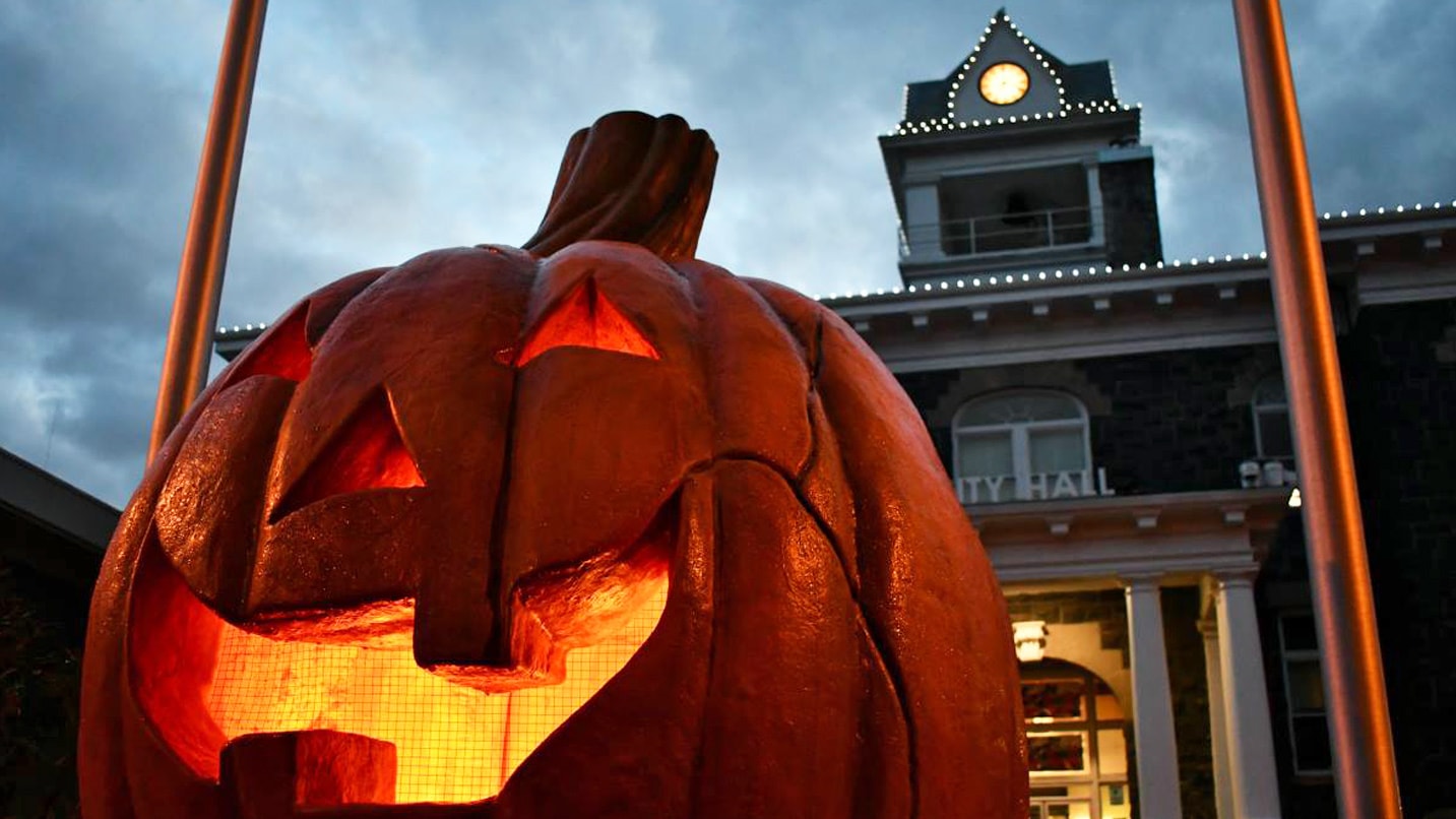 A large pumpkin sits in front of a courthouse