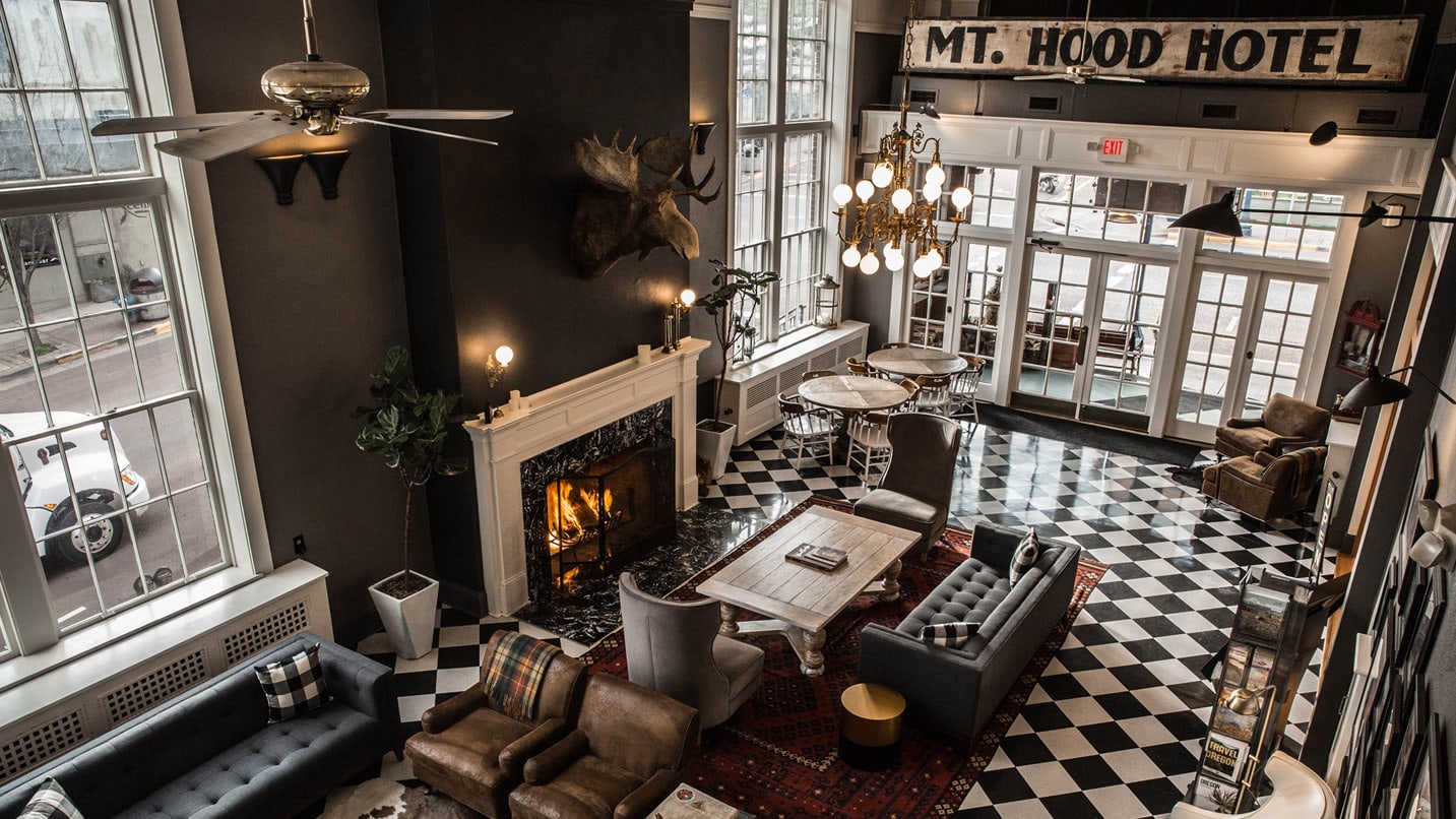An overhead shot of a hotel lobby with black and white checkered floors and a fireplace