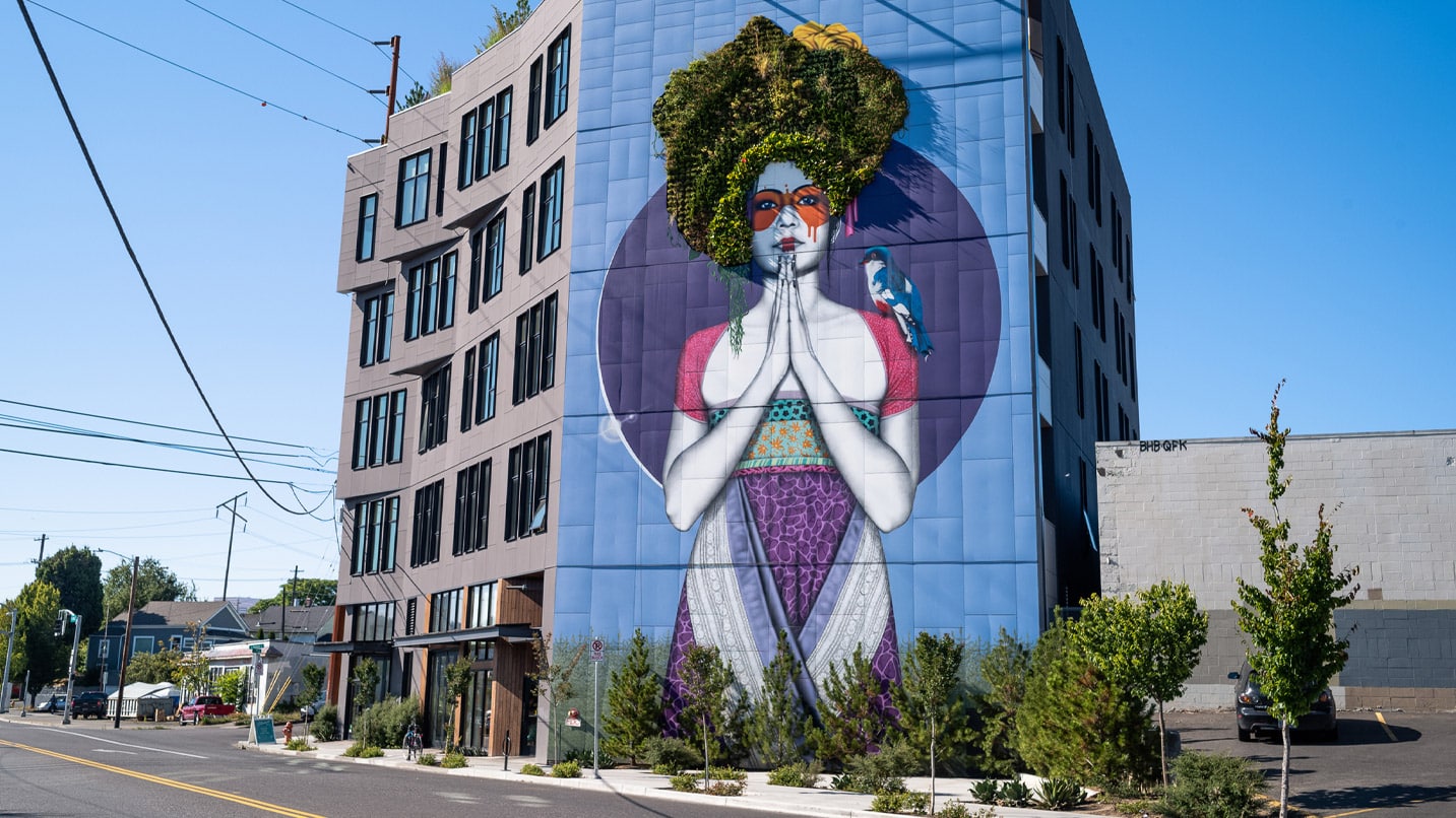 A large mural of a woman with her hair made of plants