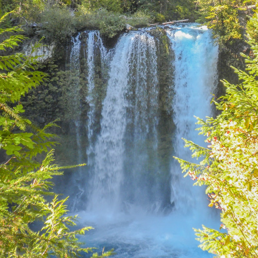 A tall waterfall flows down a cliff