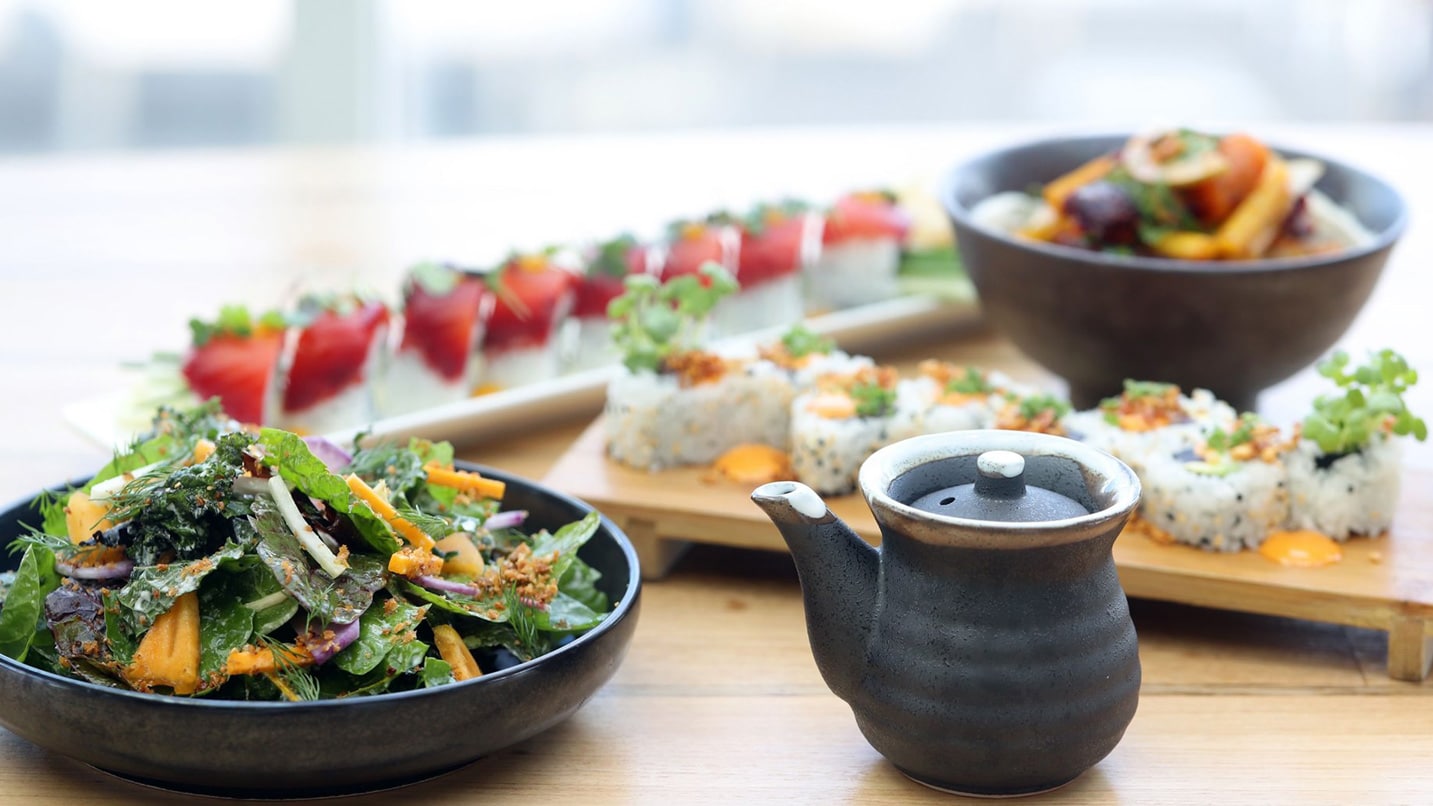 Artfully plated sushi, strawberry, salads and tea pot