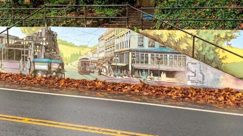 Mural alongside road shows historic buildings and people