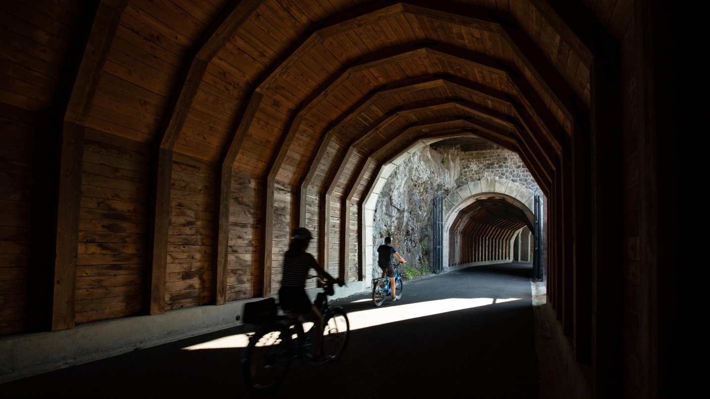 two cyclists ride through tunnel