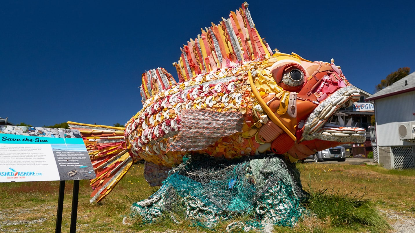 A large fish sculpture made from ocean trash